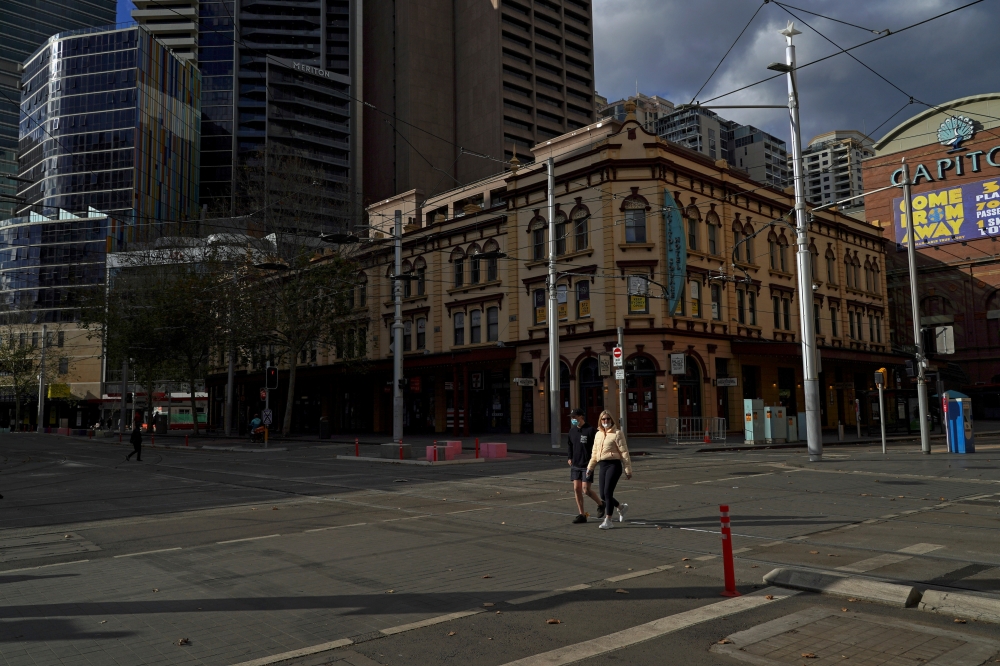 People wear protective masks in the city centre on the first day of a two-week lockdown to curb the spread of a coronavirus disease (COVID-19) outbreak in Sydney, Australia, June 26, 2021. (REUTERS/Loren Elliott)