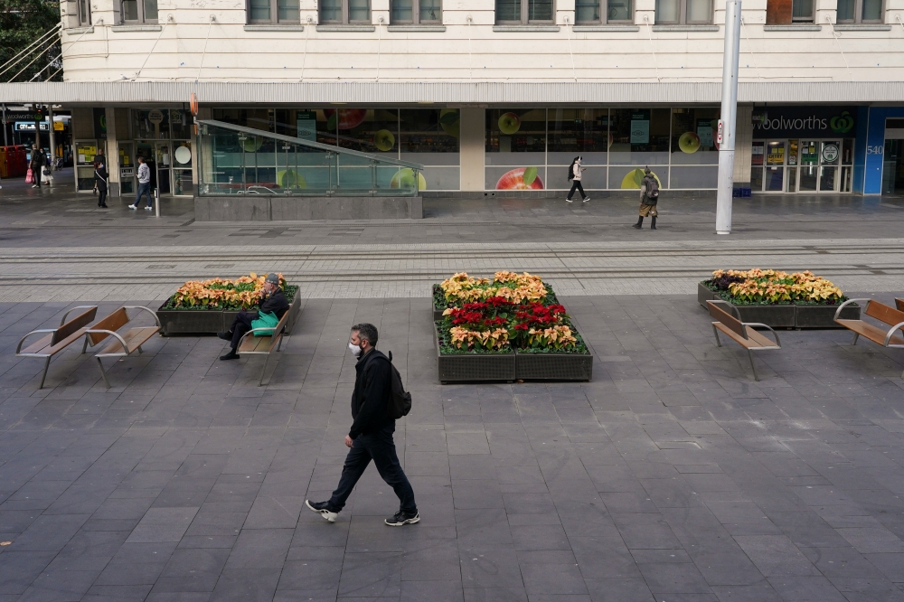 A man wearing a protective mask walks through the city centre on the first day of a two-week lockdown to curb the spread of a coronavirus disease (COVID-19) outbreak in Sydney, Australia, June 26, 2021. REUTERS/Loren Elliott
