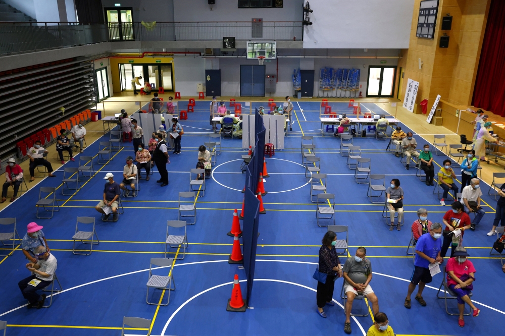 People wait to receive a dose of the AstraZeneca vaccine against the coronavirus disease (COVID-19) at a stadium in New Taipei City, Taiwan June 25, 2021. REUTERS/Ann Wang/File Photo