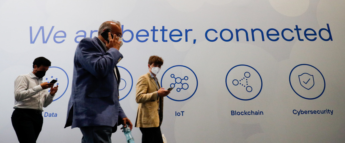People walk past a banner, at the Mobile World Congress (MWC) in Barcelona, Spain, yesterday.