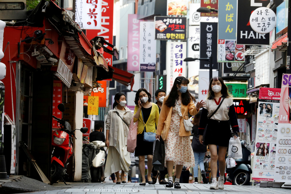 FILE PHOTO: People wearing masks walk at Myeongdong shopping district amid social distancing measures to avoid the spread of the coronavirus disease (COVID-19), in Seoul, South Korea, May 28, 2020. REUTERS/Kim Hong-Ji/File Photo
