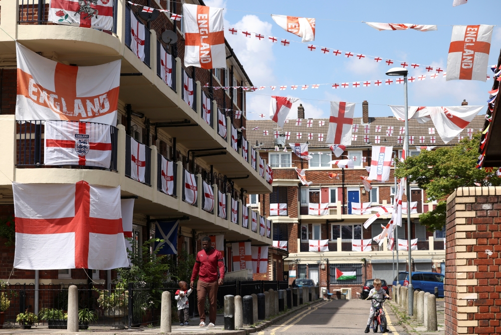 People walk through the Kirby Estate, which has been decorated with hundreds of England flags, in London, Britain, July 2, 2021. (Reuters/Henry Nicholls)