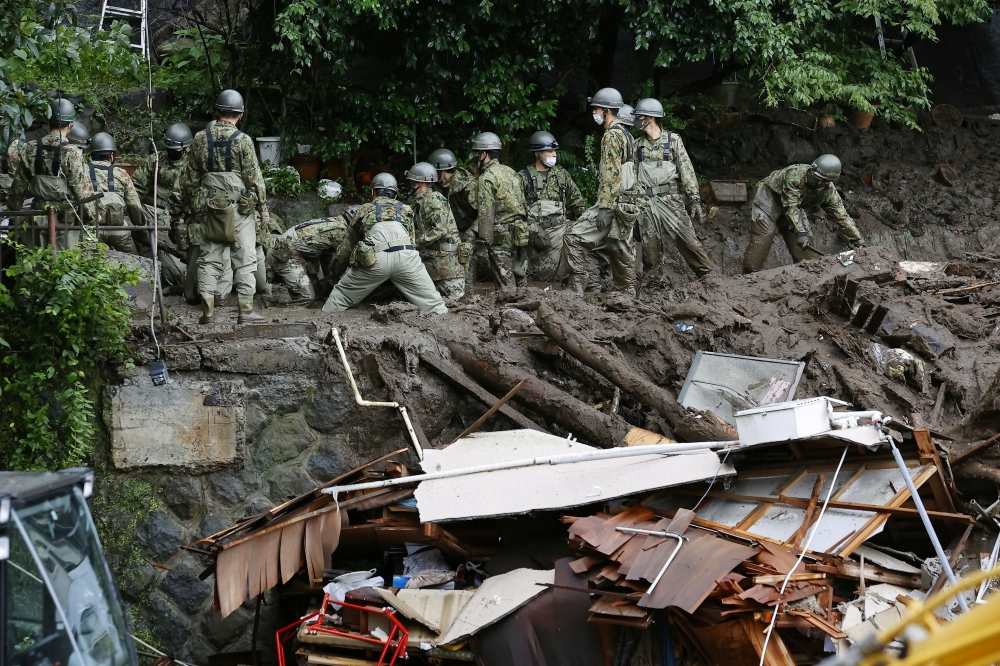Members of Japanese Self-Defence Forces conduct rescue and search operartion at a mudslide site caused by heavy rain at Izusan district in Atami, west of Tokyo, Japan July 5, 2021, in this photo taken by Kyodo. Kyodo/via REUTERS