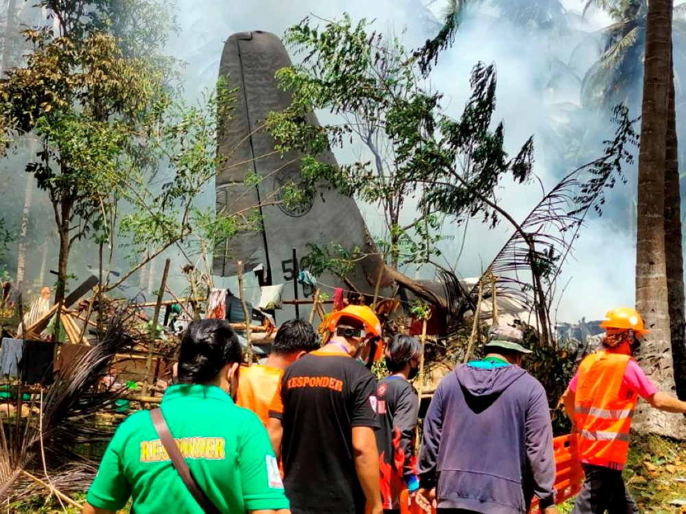 First responders work at the site after a Philippines Air Force Lockheed C-130 plane carrying troops crashed on landing in Patikul, Sulu province, Philippines July 4, 2021. Armed Forces of the Philippines - Joint Task Force Sulu/Handout via REUTERS