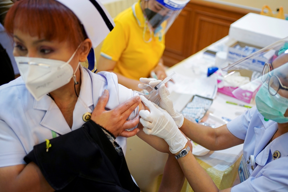 A health worker receives the Sinovac coronavirus disease (COVID-19) vaccine at the Samut Sakhon hospital in Samut Sakhon province, Thailand, February 28, 2021. REUTERS/Athit Perawongmetha/File Photo