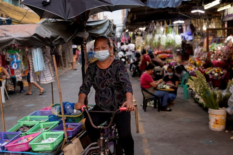 A vendor wearing a protective face mask, amid the spread of the coronavirus disease (COVID-19), cycles past a flower market in Manila, Philippines, March 12, 2021. REUTERS/Eloisa Lopez
