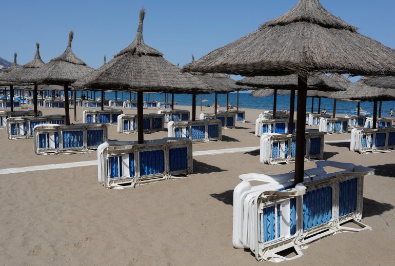 Unoccupied beach lounge chairs are seen on a half empty beach by the Mediterranean Sea, amid the coronavirus disease (COVID-19) pandemic, in Fuengirola, southern Spain, May 25, 2021. REUTERS/Jon Nazca