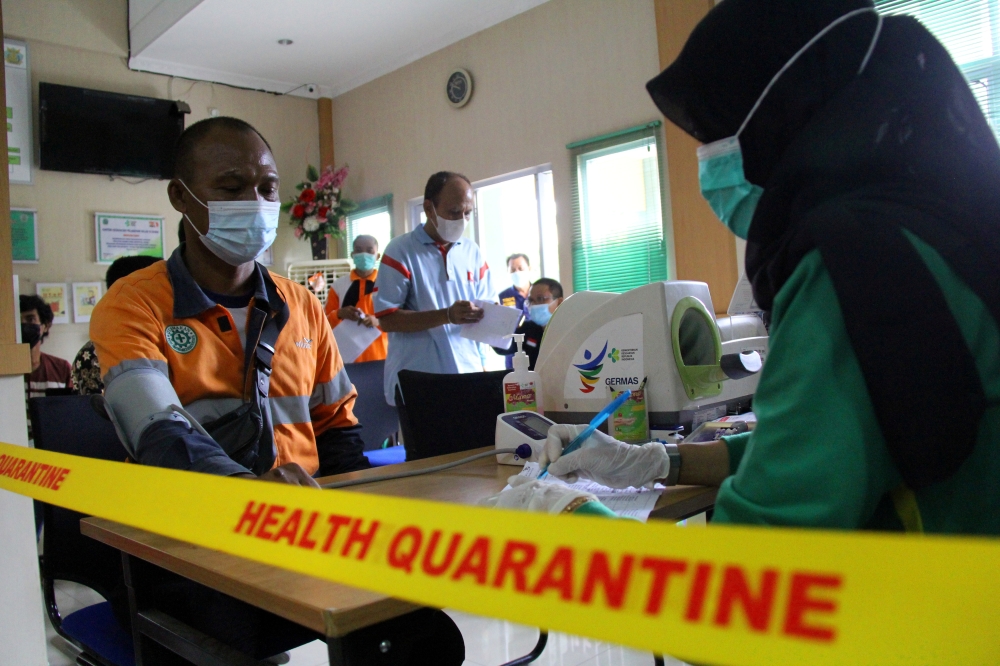 A worker undergoes health screening at a port health office before receiving his dose of the coronavirus disease (COVID-19) vaccine, in Riau province, Indonesia July 9, 2021. Antara Foto/Aswaddy Hamid/via REUTERS