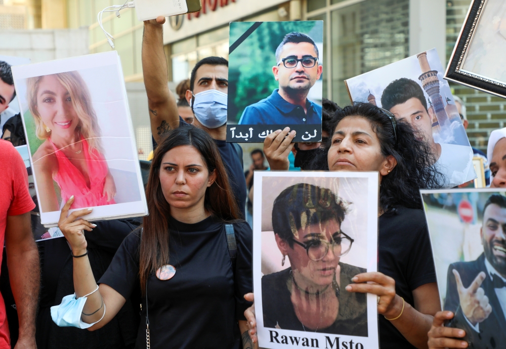 Family members of some of the victims of the August 4 explosion at Beirut port, carry their pictures during a protest demanding justice, in Beirut, Lebanon July 9, 2021. REUTERS/Mohamed Azakir
