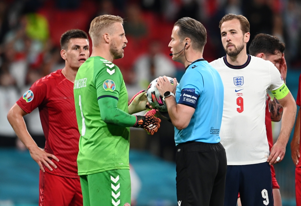 Denmark's Kasper Schmeichel talks to referee Danny Makkelie before he awards England a penalty after a VAR review Pool via REUTERS/Andy Rain
