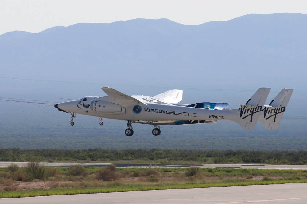 Virgin Galactic's passenger rocket plane VSS Unity, borne by twin-fuselage carrier jet dubbed VMS Eve, takes off with billionaire entrepreneur Richard Branson and his crew for travel to the edge of space at Spaceport America near Truth or Consequences, Ne