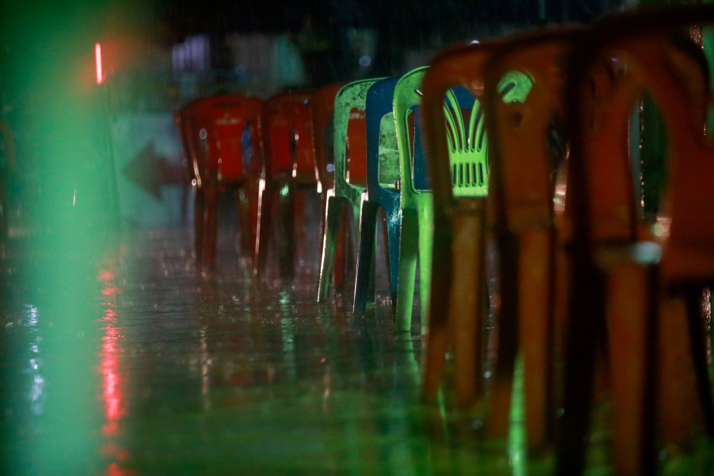Plastic chairs, for people who come to queue overnight for a free coronavirus disease (COVID-19) test, are seen in the rain, at a temple in Bangkok, Thailand July 10, 2021. REUTERS/Soe Zeya Tun/File Photo