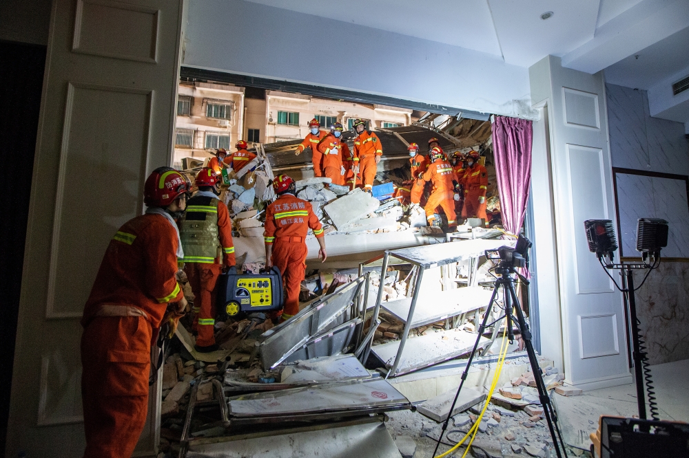 Rescue workers work at the site where a hotel building collapsed in Suzhou, Jiangsu province, China July 12, 2021. Picture taken July 12, 2021. China Daily via REUTERS 