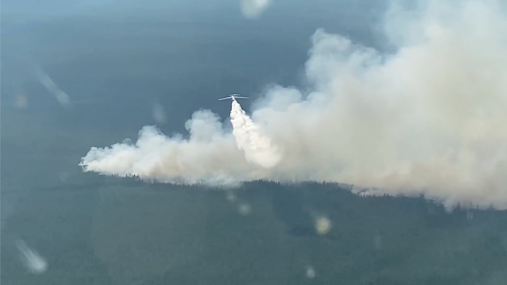 A plane makes a water drop to fight a forest fire in the region of Yakutia in eastern Siberia, Russia, in this still image taken from video released July 14, 2021. Ministry of Defence of the Russian Federation/Handout via REUTERS