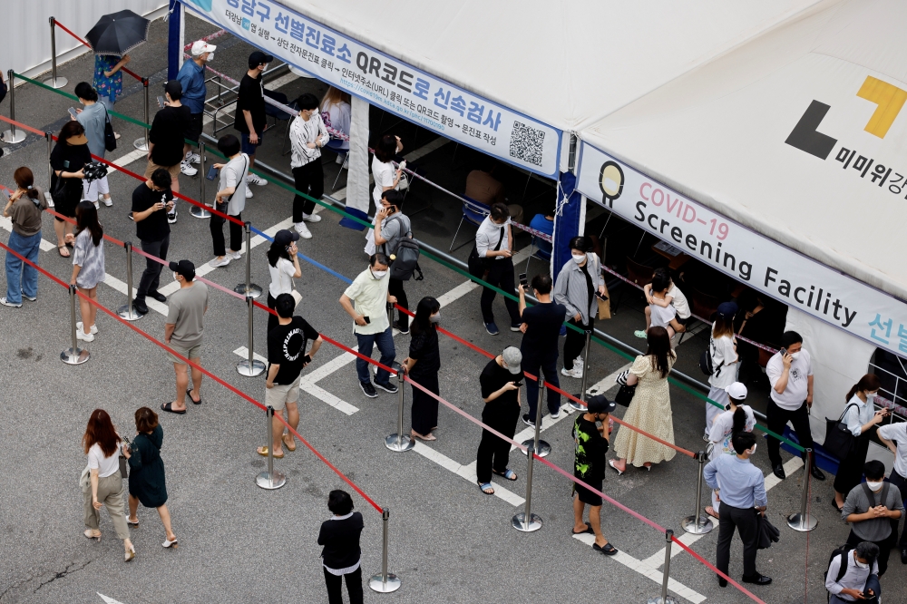 People wait in line for a coronavirus disease (COVID-19) test at a testing site which is temporarily set up at a public health center in Seoul, South Korea, July 9, 2021. REUTERS/ Heo Ran/File Photo