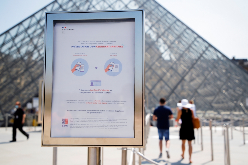 A sign asking for visitors' health passes is seen in front of the Louvre Pyramid amid the coronavirus disease (COVID-19) outbreak in Paris, France, July 21, 2021. (REUTERS/Sarah Meyssonnier)