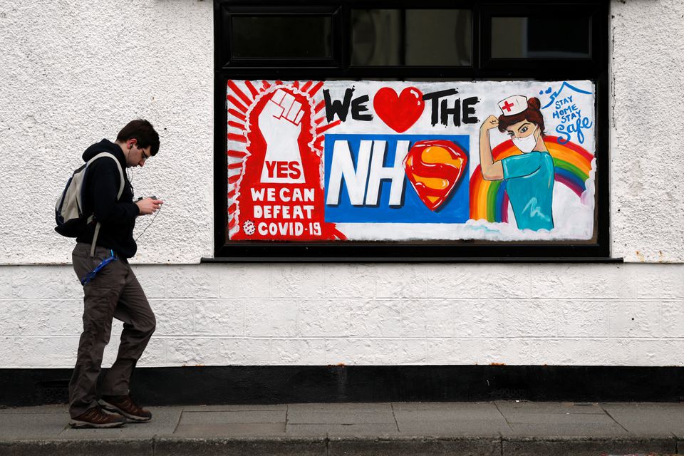 A man walks past a graffiti in support of the NHS, following the outbreak of the coronavirus disease (COVID-19), Marske-by-the-Sea, Britain, April 29, 2020. REUTERS/Lee Smith/Files