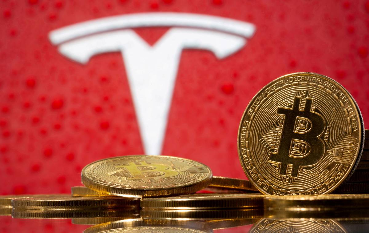 FILE PHOTO: Representations of virtual currency bitcoin are seen in front of Tesla logo in this illustration taken, February 9, 2021. REUTERS/Dado Ruvic/File Photo
