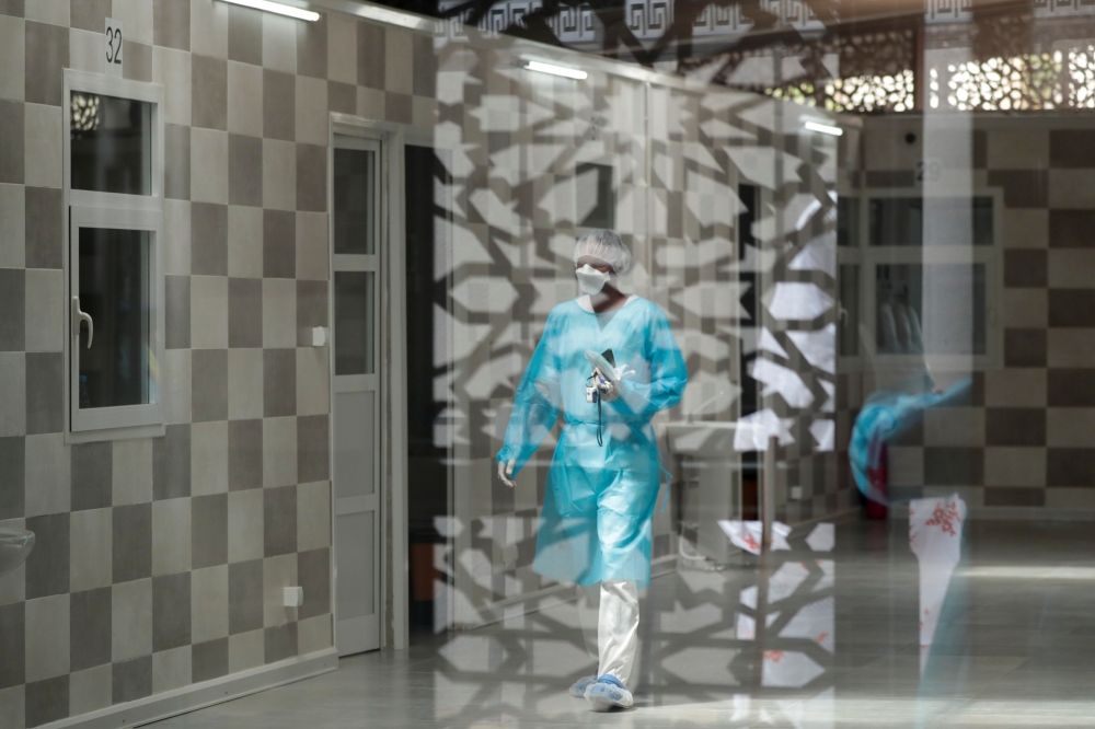 Health workers are pictured through a window at the infectious diseases department of the Fann University Hospital in Dakar, amid a surge of coronavirus disease (COVID-19) cases in Senegal July 28, 2021. Picture taken July 28, 2021.REUTERS/Zohra Bensemra