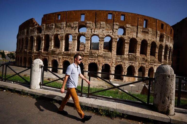 A person walks without wearing a mask as Italy lifts mandatory masks outdoors thanks to a decline in the coronavirus disease (COVID-19) cases and hospitalisations, in Rome, Italy, June 28, 2021. REUTERS/Guglielmo Mangiapane