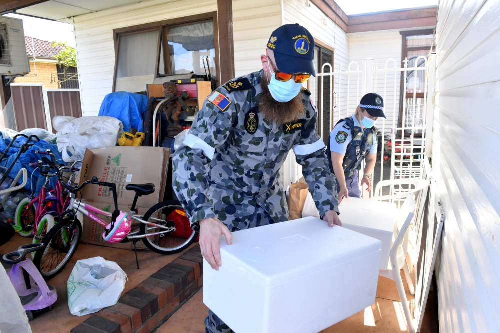 Australian Defence Force personnel and NSW police deliver emergency food parcels for people in lockdown in the Fairfield suburb in the southwest of Sydney, Australia, August 2, 2021. AAP Image/Mick Tsikas via Reuters 