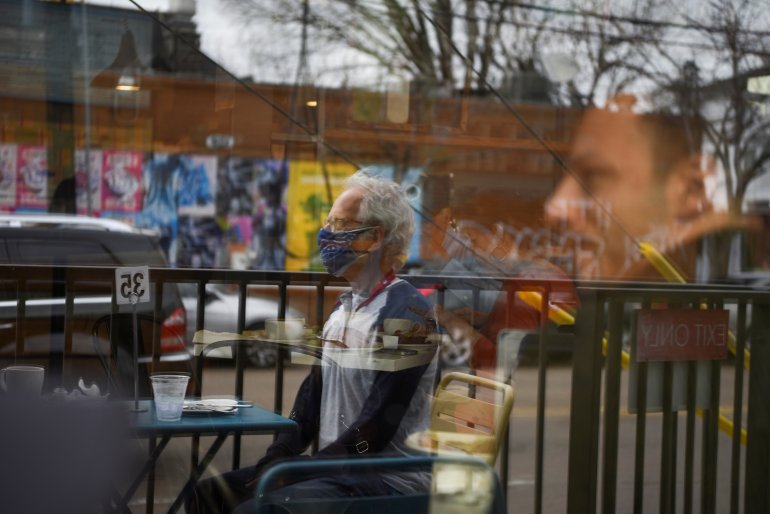FILE PHOTO: Herb Pasternak wears a mask while dining outdoors as the state of Texas lifts its mask mandate and allows businesses to reopen at full capacity during the coronavirus disease (COVID-19) pandemic in Houston, Texas, U.S., March 10, 2021. REUTERS