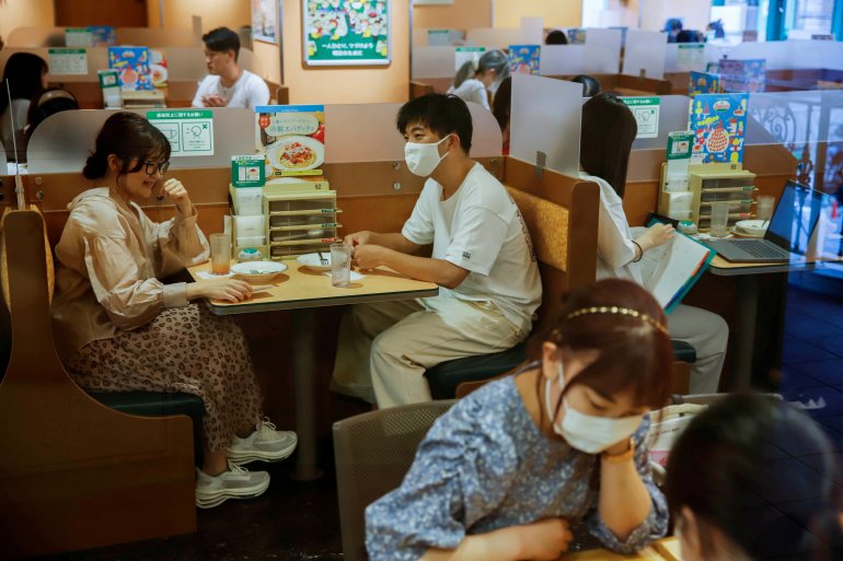 FILE PHOTO: People sit in a restaurant using plexiglass separators to protect customers from coronavirus (COVID-19) disease in the Shibuya area of Tokyo, Japan, July 29, 2021. REUTERS/Androniki Christodoulou/File Photo