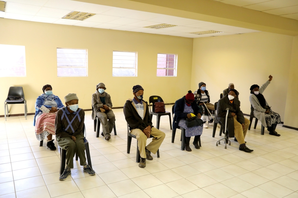 People wearing protective masks sit ahead of a vaccination, as South Africa rolls out the coronavirus disease (COVID-19) vaccines to the elderly at the Munsieville Care for the Aged Centre outside Johannesburg, South Africa May 17, 2021. REUTERS/Siphiwe S