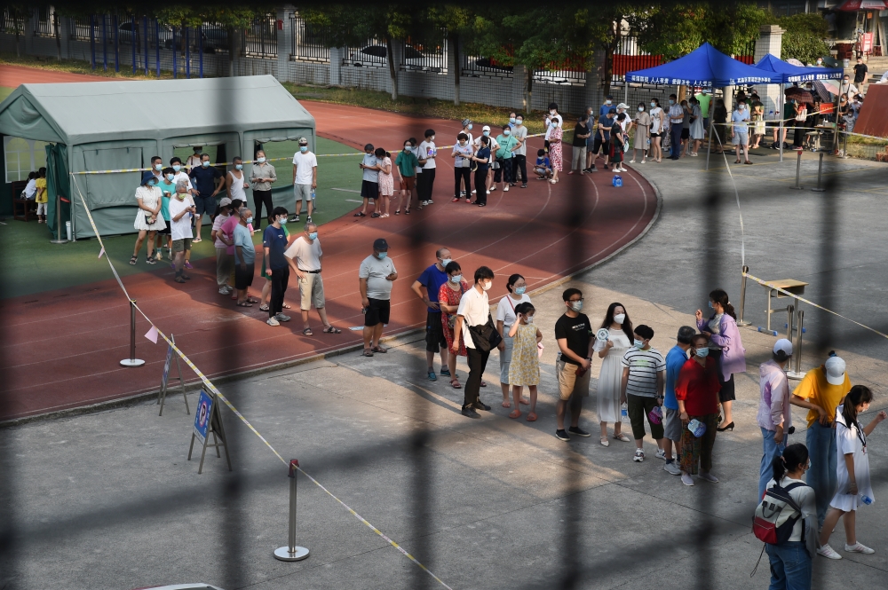 Residents line up at a nucleic acid testing site during a citywide mass testing following new cases of the coronavirus disease (COVID-19) in Wuhan, Hubei province, China, August 3, 2021. Reuters/Stringer 