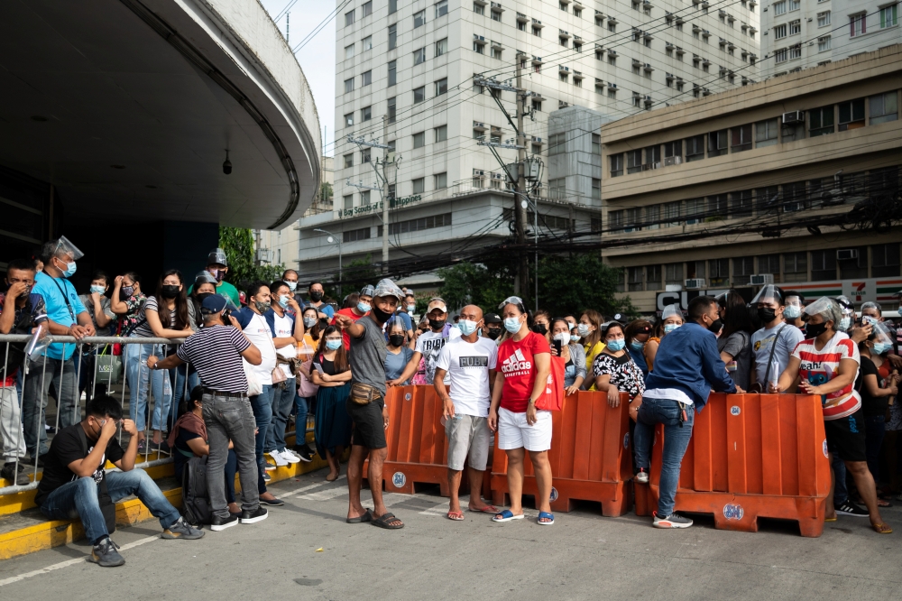 Filipinos waiting to be vaccinated against the coronavirus disease (COVID-19) gather outside a mall, a day before stricter lockdown measures are implemented, in Manila, Philippines, August 5, 2021. REUTERS/Lisa Marie David
