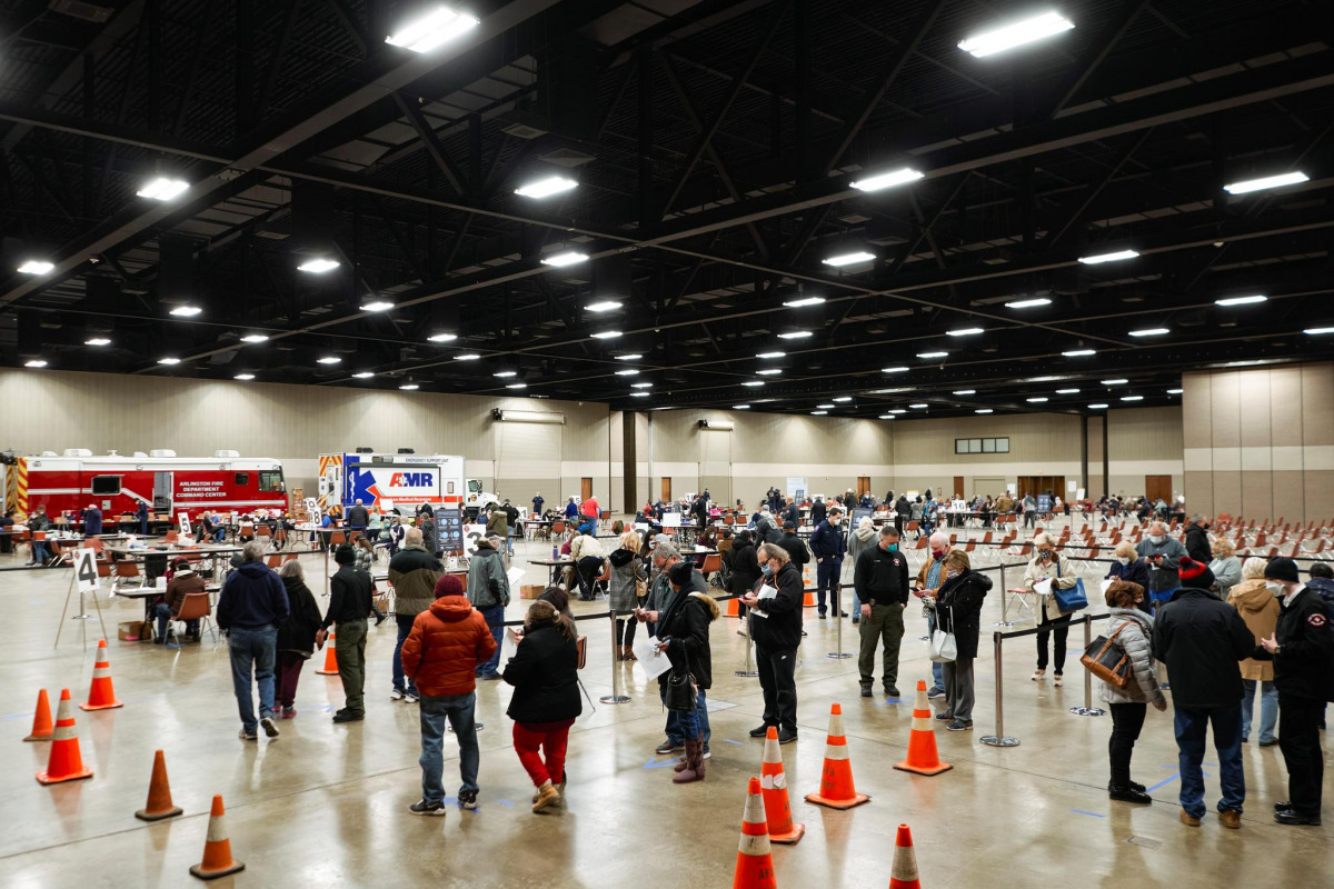 FILE PHOTO: People wait in line to be inoculated against the coronavirus disease (COVID-19) at a vaccination site at the Esports Stadium Arlington & Expo Center in Arlington, Texas, U.S. February 12, 2021.  REUTERS/Cooper Neill