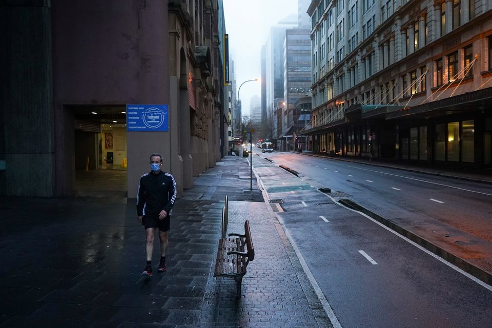 A pedestrian wearing a protective face mask walks through the deserted city centre at morning commute hour during a lockdown to curb the spread of a coronavirus disease (COVID-19) outbreak in Sydney, Australia, June 30, 2021. REUTERS/Loren Elliott


