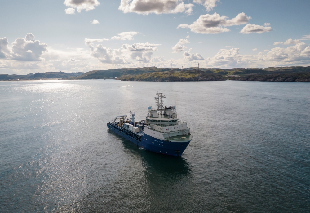 A vessel sails along a coast line as it lays undersea fiber optic communications cable near the village of Teriberka, on the Barents Sea, Russia August 6, 2021. REUTERS/Stringer