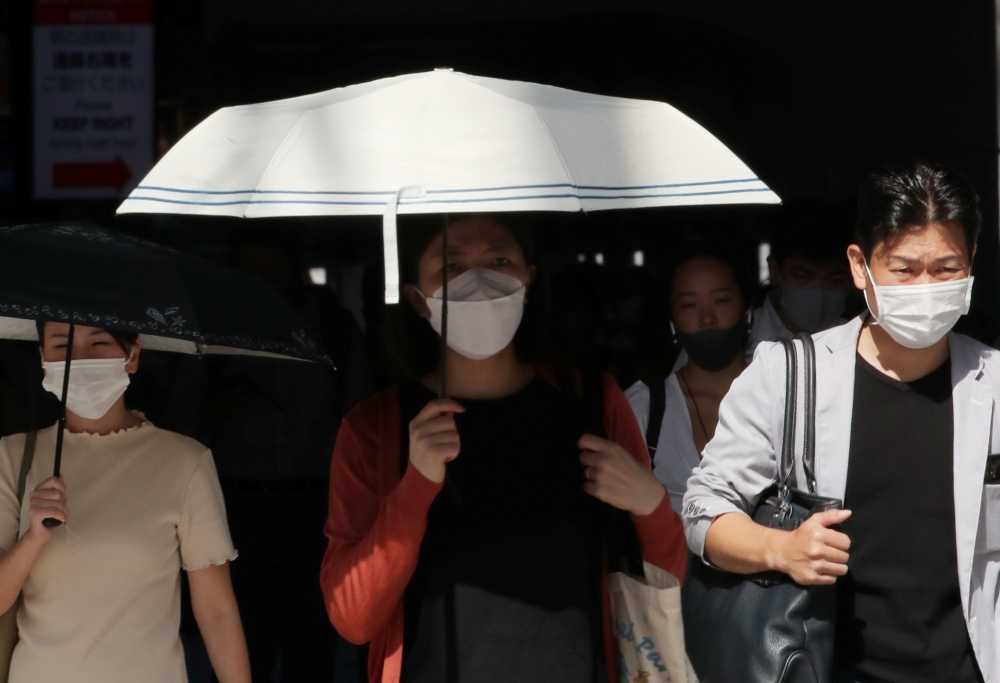 People wearing protective masks make their way, amid the coronavirus disease (COVID-19) outbreak, in Tokyo, Japan, August 10, 2021. REUTERS/Kim Kyung-Hoon