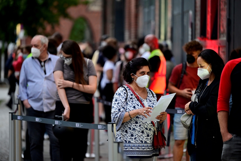 People queue to receive a vaccine against the coronavirus disease (COVID-19), during a night of vaccinations with music, at the Arena Treptow vaccination centre in Berlin, Germany, August 9, 2021. John Macdougall/Pool via REUTERS