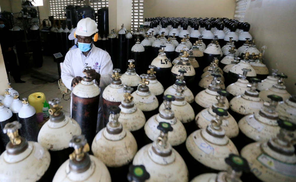 Walter Otieno, plant operator at Hewatele, an innovative oxygen supply company,, arranges empty oxygen medical cylinder tanks amid the coronavirus disease (COVID-19) pandemic, at the Hewatele oxygen plant in Nairobi, Kenya August 3, 2021. Picture taken Au