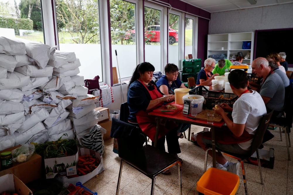 Volunteers prepare food for people affected by the floods after heavy rainfall in Jupille, Belgium, August 9, 2021. REUTERS/Johanna Geron