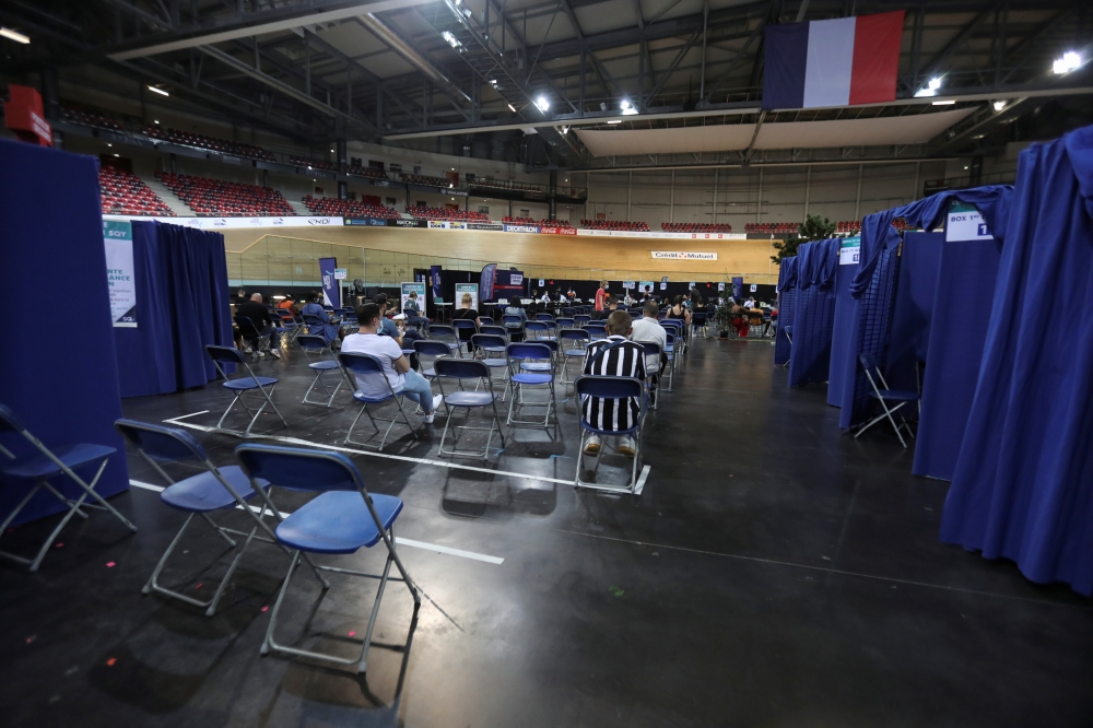 People wait after being injected with a dose of the Pfizer-BioNTech 