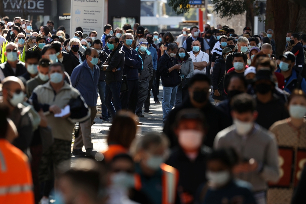 People wait in line outside a coronavirus disease (COVID-19) vaccination centre at Sydney Olympic Park during a lockdown to curb the spread of an outbreak in Sydney, Australia, August 16, 2021. REUTERS/Loren Elliott