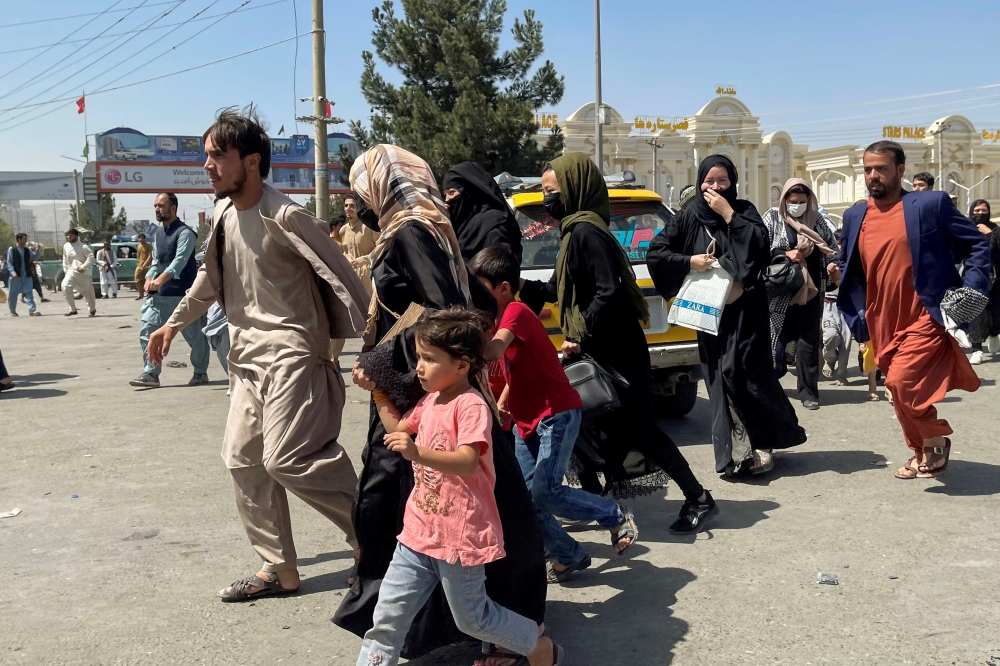 People try to get into Hamid Karzai International Airport in Kabul, Afghanistan August 16, 2021. REUTERS