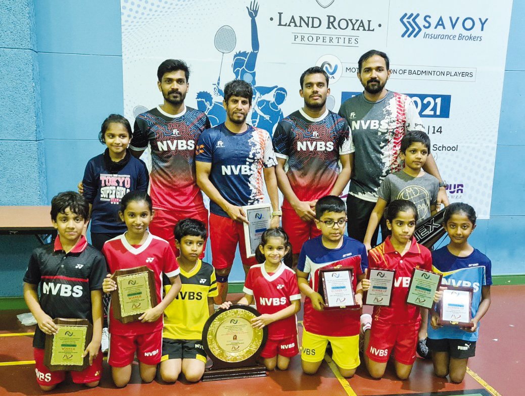 Head coach Manoj Sahibjan and officials posing for a photograph with players of NVBS who won podium spots during the LSA Open Badminton Tournament held at Middle East International School in Doha.