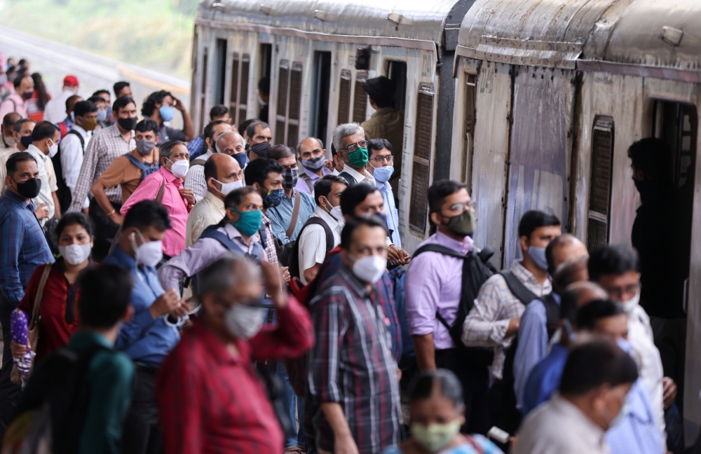 Commuters wearing protective face masks wait to board a suburban train after authorities resumed train services for vaccinated passengers amid the coronavirus disease (COVID-19) pandemic, in Mumbai, India, August 17, 2021. REUTERS/Francis Mascarenhas