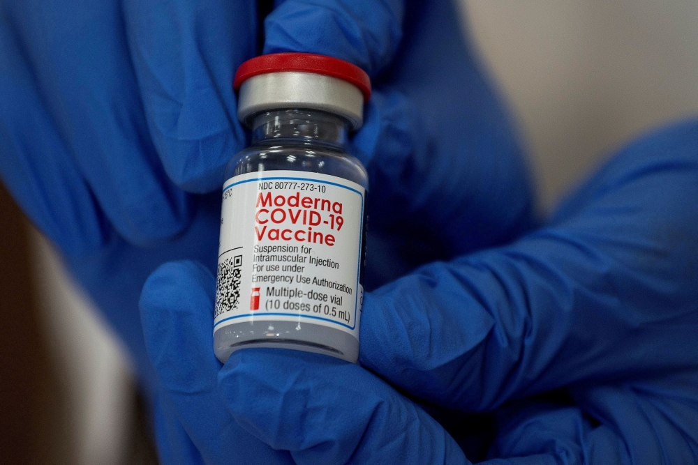 An employee shows the Moderna COVID-19 vaccine at Northwell Health's Long Island Jewish Valley Stream hospital in New York, U.S., December 21, 2020. REUTERS/Eduardo Munoz/File Photo
