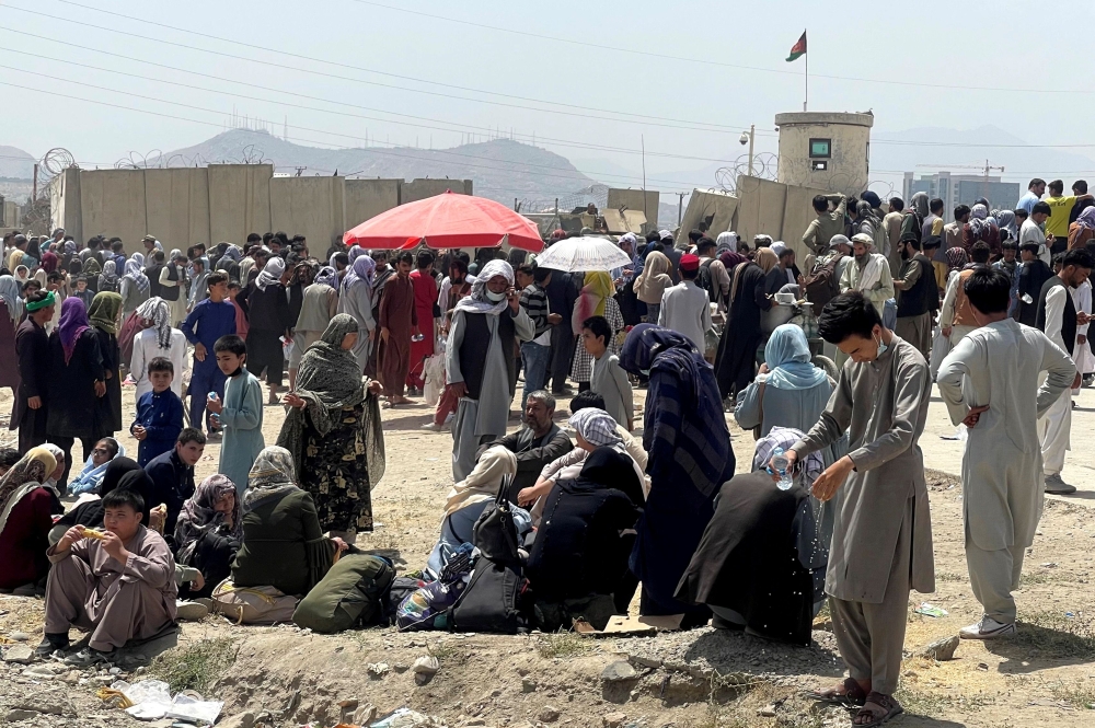 People wait outside Hamid Karzai International Airport in Kabul, Afghanistan August 17, 2021. REUTERS