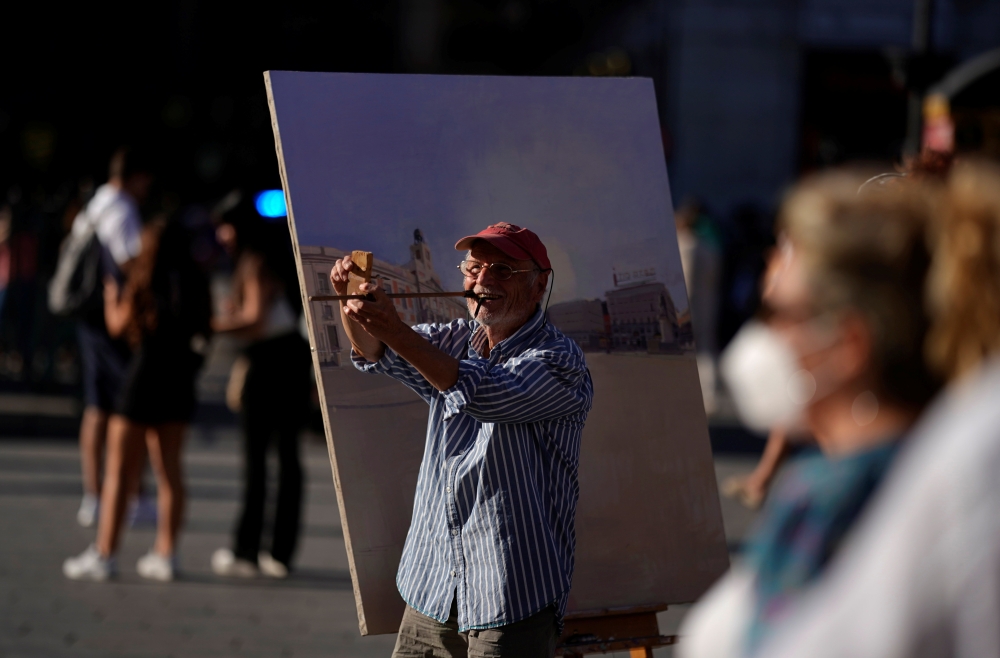 Spanish artist Antonio Lopez checks the perspectives during one of his sessions to paint the famous Puerta del Sol square in Madrid, Spain, August 4, 2021. Picture taken August 4, 2021. REUTERS/Juan Medina