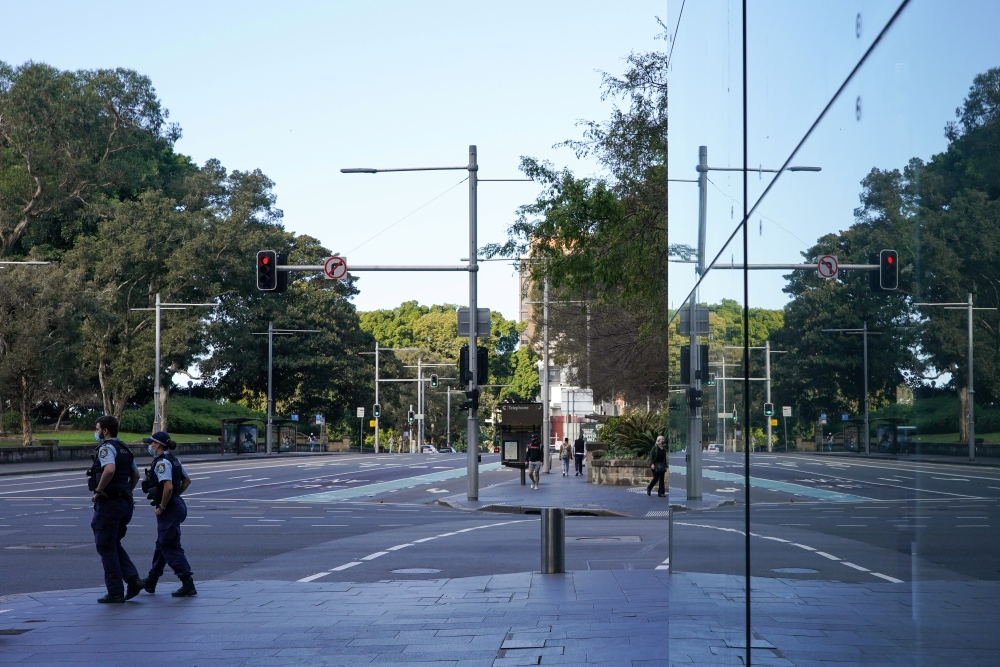 Police officers patrol the quiet city centre during a lockdown to curb the spread of a coronavirus disease (COVID-19) outbreak in Sydney, Australia, August 18, 2021. REUTERS/Loren Elliott