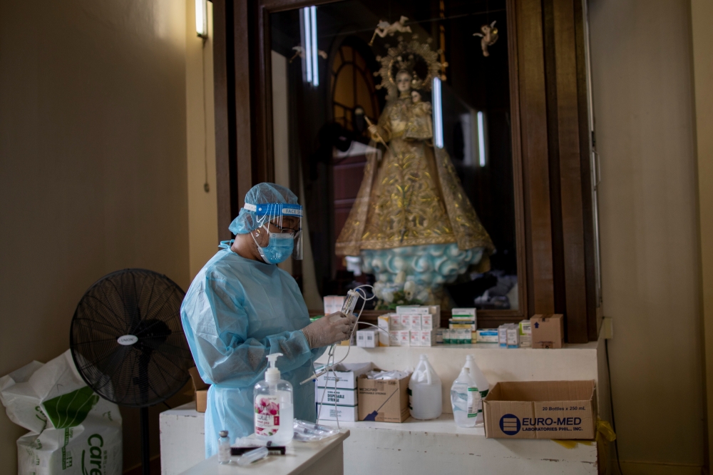 A health worker prepares Remdesivir for a coronavirus disease (COVID-19) patient admitted in the chapel of Quezon City General Hospital turned into a COVID-19 ward amid rising infections, in Quezon City, Metro Manila, Philippines, August 20, 2021. REUTERS