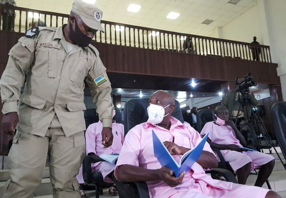 Paul Rusesabagina, portrayed as a hero in a Hollywood movie about Rwanda's 1994 genocide, talks to a prison guard inside the courtroom in Kigali, Rwanda February 17, 2021. Reuters/Clement Uwiringiyimana/File Photo