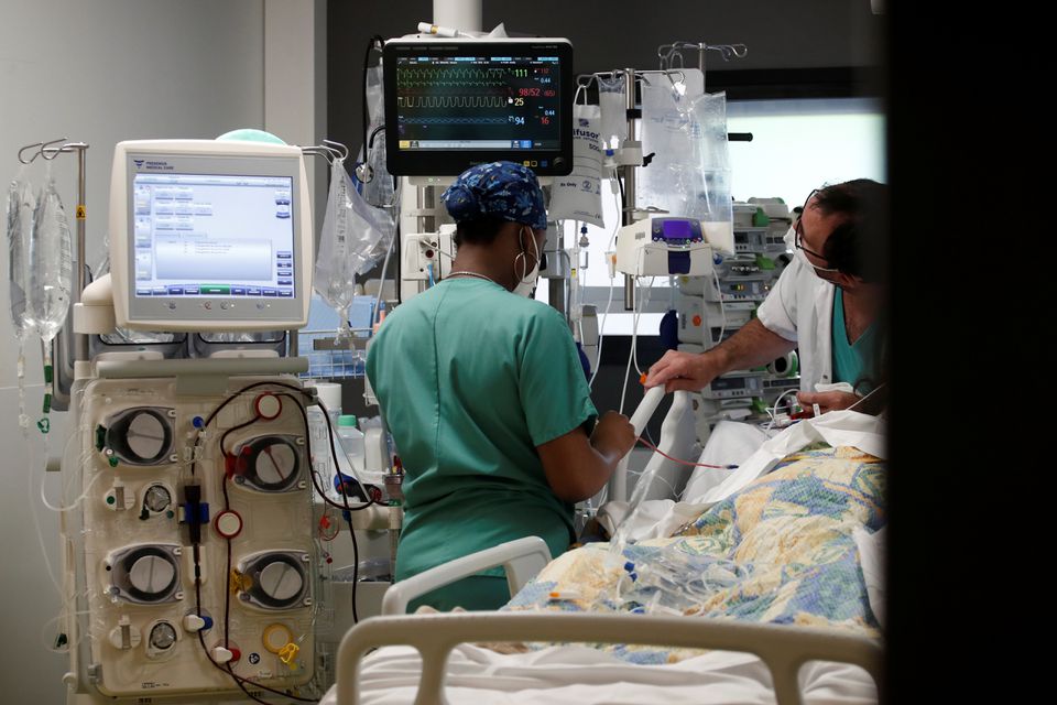 FILE PHOTO - Healthcare workers adjust medical equipment in the Intensive Care Unit (ICU) at the Centre Cardiologique du Nord private hospital in Saint-Denis, near Paris, amid the coronavirus disease (COVID-19) pandemic in France, May 4, 2021. REUTERS/Ben
