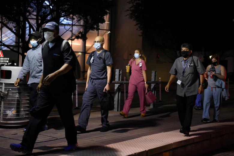 Healthcare workers walk through the Texas Medical Center during a shift change in Houston, Texas, July 8, 2020. REUTERS/Callaghan O'Hare

